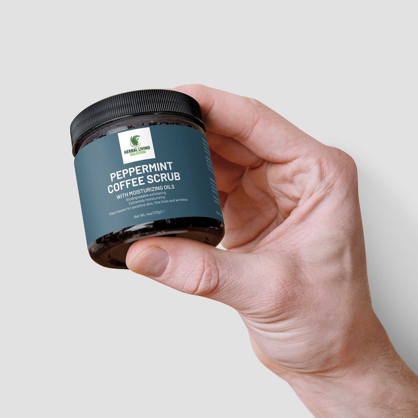 Hand holding jar of Peppermint Coffee Scrub with moisturizing oils for exfoliation and skin rejuvenation