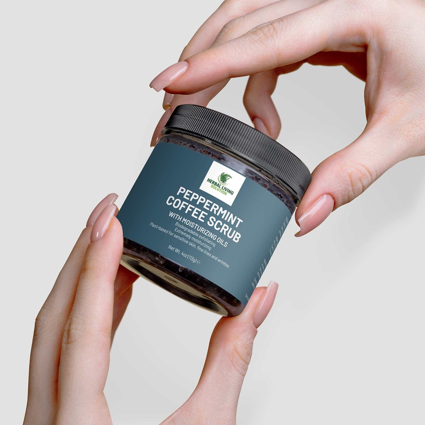Hand holding jar of Peppermint Coffee Scrub with moisturizing oils for skin exfoliation and hydration