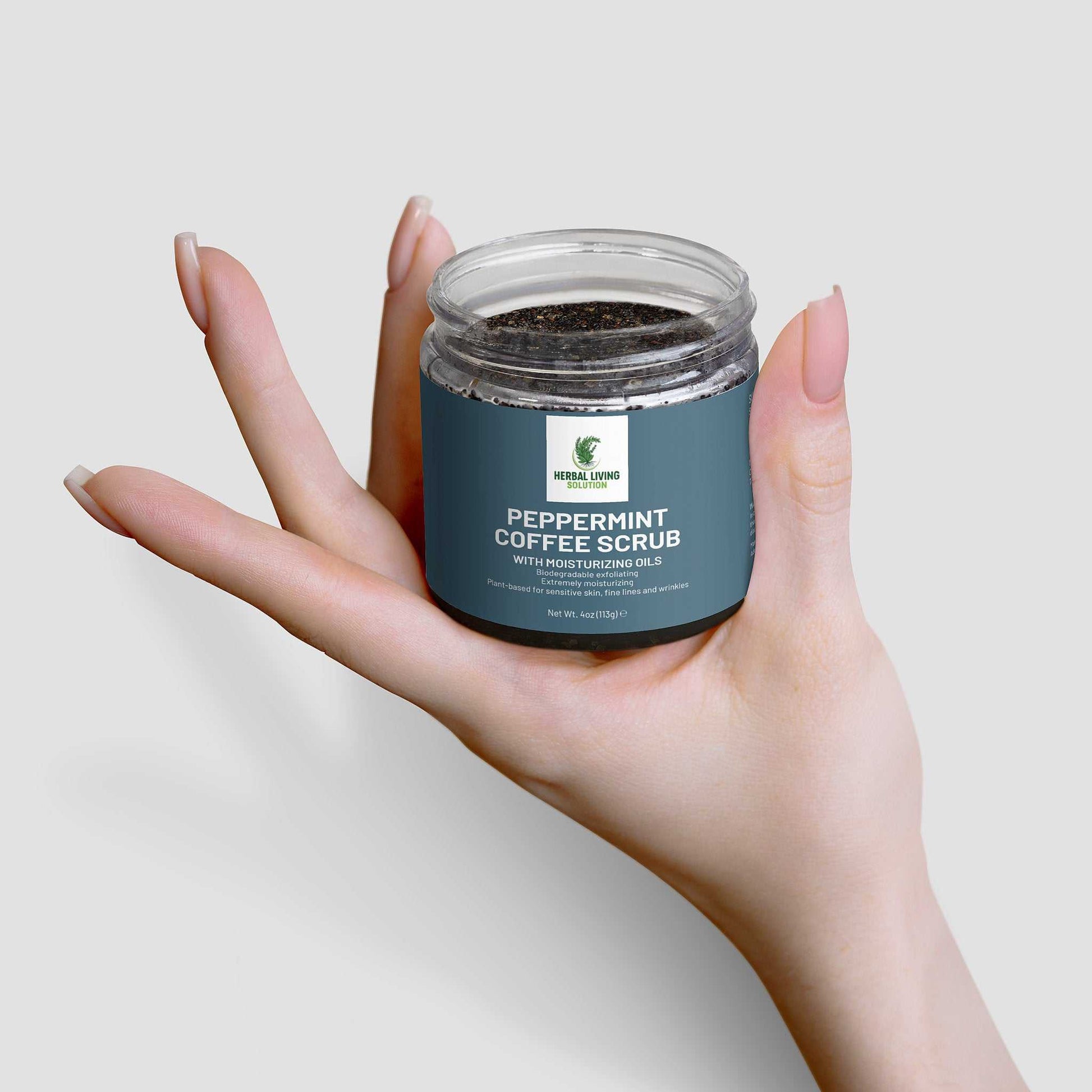 Hand holding jar of Peppermint Coffee Scrub with moisturizing oils for skin exfoliation and hydration
