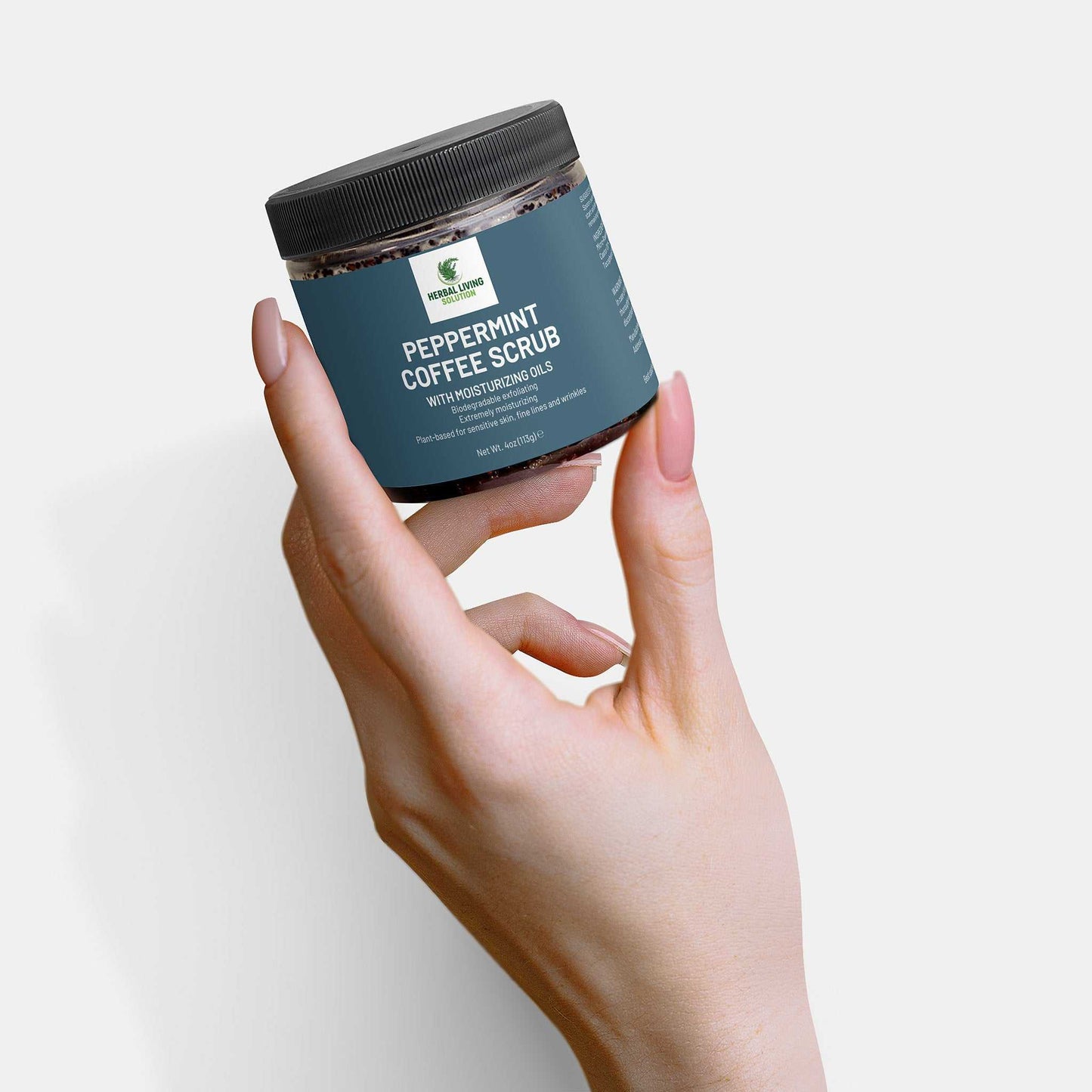 Hand holding jar of Peppermint Coffee Scrub with moisturizing oils for skin exfoliation and hydration